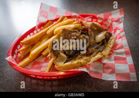 Un sale Philly Cheesesteak avec oignons poivrons et champignons, frites sur le côté Banque D'Images