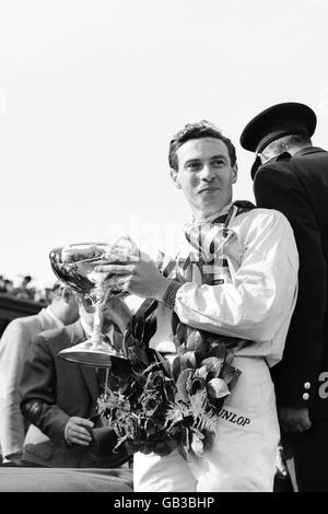 Course automobile Formula One - Grand Prix de Grande-Bretagne - Aintree.Le vainqueur de la course, Jim Clark, se tourne pour montrer le trophée à la foule après avoir remporté le Grand Prix de Grande-Bretagne Banque D'Images