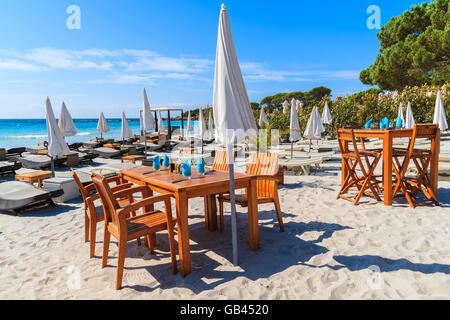 Tables de restaurant sur le sable blanc de la plage de Palombaggia, Corse, France Banque D'Images