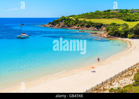 Couple de jeunes gens non identifiés se détendre sur la magnifique grande plage de Sperone, Corse, France Banque D'Images