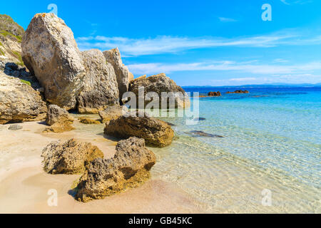 Rochers dans l'eau de mer cristalline sur belle grande plage de Sperone, Corse, France Banque D'Images