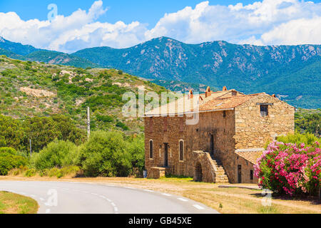 Maison traditionnelle Corse construit à partir de pierres le long d'une route au paysage de montagne corse, France Banque D'Images