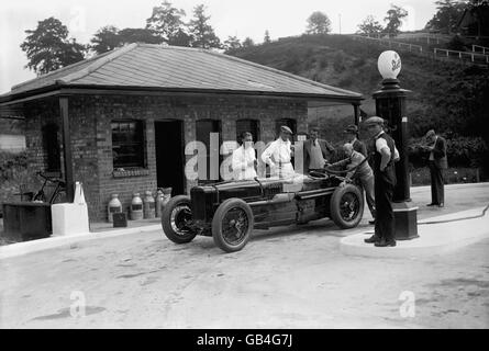 Jack Dunfee, pilote de course, se remplit à la station-service de Brooklands. Banque D'Images