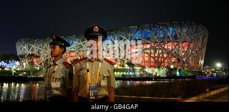 Les responsables chinois de la sécurité se tiennent devant le Stade National lors d'une répétition de la cérémonie d'ouverture des Jeux Olympiques à Beijing, en Chine. Banque D'Images