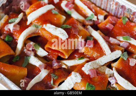 Paccheri, pâtes au four avec une sauce tomate, mozzarella, bacon et le basilic. Des spécialités culinaires italiennes. Préparation des matières, avant de cuire Banque D'Images