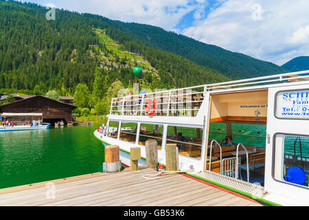 Lac WEISSENSEE, AUTRICHE - Jul 6, 2015 Tourisme : amarrage bateau à la jetée sur les rives du lac Weissensee en été Alpes paysage de pe Banque D'Images