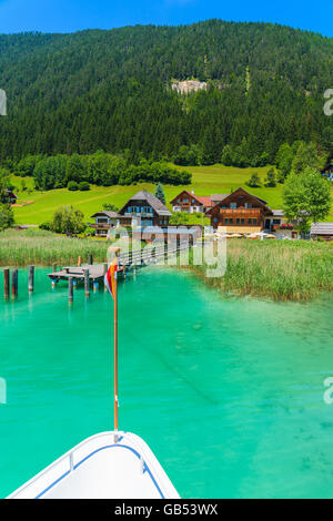 Maisons sur les rives du magnifique lac alpin Weissensee en été paysage de montagnes des Alpes - vue de bateau de tourisme, Autriche Banque D'Images