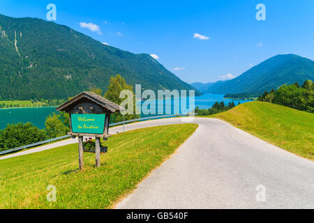 Vue sur lac Weissensee avec signe le long d'une route avec les mots 'Bienvenue en Autriche' peint accueil à bord, Autriche Banque D'Images