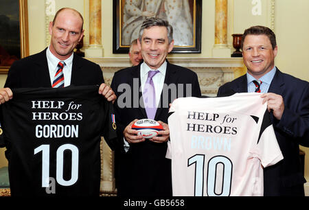 Le Premier ministre Gordon Brown reçoit des maillots de rugby de Lawrence Dallaglio et Scott Gibbs, lors d'une réception à Downing Street pour les joueurs de rugby internationaux qui participent au match de charité « Help for Heroes » à Twickenham ce samedi. Banque D'Images