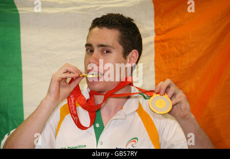 Le sprinter Jason Smyth, 21 ans, de Derry, membre de l'équipe paralympique irlandaise qui a remporté deux des trois golds irlandais lors des sprints de 200 et 100 mètres, montre ses médailles ce soir alors que l'équipe a touché le sol de la maison en train d'accrocher un lot de médailles. Banque D'Images