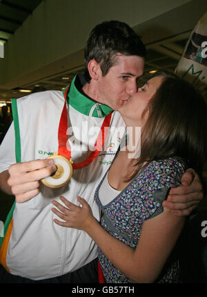 Le coureur Michael McKillop, 18 ans, de Glentormley, Co Antrim, membre de l'équipe paralympique primée d'Irlande, reçoit l'accueil d'un héros de sa petite amie Annemarie, (nom de famille non pris) ce soir alors que l'équipe a touché le sol de la maison en train d'accrocher un lot de médailles. Banque D'Images