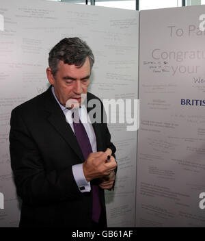 Le Premier ministre Gordon Brown signe une carte alors qu'il rencontre l'équipe paralympique de Grande-Bretagne lorsqu'ils se mettent de l'avion de Pékin à l'aéroport de Heathrow, à Londres. Banque D'Images