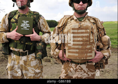 Une comparaison des vêtements de l'armée britannique et des armures corporelles. À gauche, un soldat porte des engins délivrés avant 2003, y compris la petite plaque d'armure qui ne couvre que le cœur. À droite, un soldat porte les vêtements actuellement délivrés, y compris une plaque beaucoup plus grande d'armure du corps qui couvre toute la poitrine. Banque D'Images