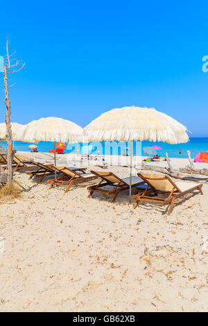 Des chaises longues avec parasols sur la plage de Bodri, Corse, France Banque D'Images