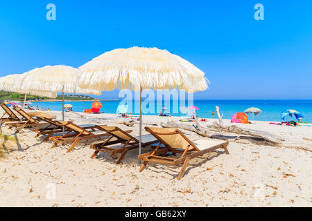 Des chaises longues avec parasols sur la plage de Bodri, Corse, France Banque D'Images