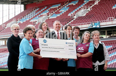 Sir Geoff Hurst (au centre) avec les neuf travailleurs à domicile qui ont chacun gagné une part d'un peu plus de 7 millions de livres lors du tirage au sort EuroMillions de vendredi, fêtez à Upton Park, stade du club de football West Ham United. Banque D'Images