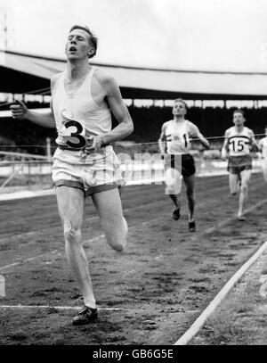 Athlétisme - Championnat AAA - White City.Roger Bannister casse la bande pour gagner le mile dans un nouveau championnat meilleur Banque D'Images