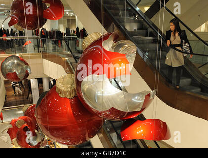 Des boules rouges géantes dans le grand magasin Selfridges du centre de Londres sont exposées. Ils font partie d'une œuvre d'art de Claire Morgan et font partie des décorations de Noël de cette année. Banque D'Images