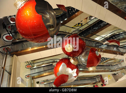 Des boules rouges géantes dans le grand magasin Selfridges du centre de Londres sont exposées. Ils font partie d'une œuvre d'art de Claire Morgan et font partie des décorations de Noël de cette année. Banque D'Images