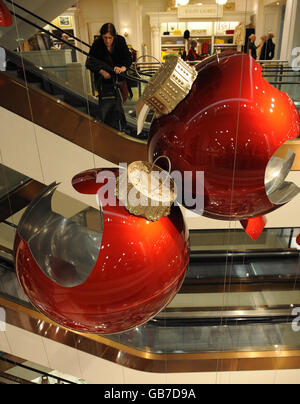 Des boules rouges géantes dans le grand magasin Selfridges du centre de Londres sont exposées. Ils font partie d'une œuvre d'art de Claire Morgan et font partie des décorations de Noël de cette année. Banque D'Images