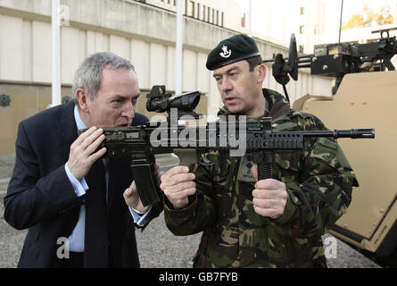 Le lieutenant-colonel James Daniels du régiment des fusils à Canon rayé, John Hutton, secrétaire de la Défense, montre la vue télescopique du fusil SA80 et est maintenant détaché à l'unité des essais et du développement de l'infanterie lors d'une visite pour voir le véhicule blindé Jackal de l'armée à la caserne Wellington, à Londres. Banque D'Images