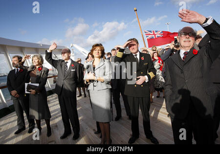 Le duc d'Édimbourg (3e à gauche) protège ses yeux du soleil tout en regardant un avion à réaction Harrier passer devant la reine Elizabeth 2 à côté du capitaine Ian McNaught (2e à droite) lors d'une visite du navire à Southampton. Banque D'Images