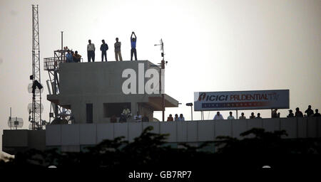 Les fans indiens regardent le match depuis un toit à proximité tandis que les mauvaises lumières s'arrêtent pendant la troisième journée internationale au stade Green Park à Kanpur, en Inde. Banque D'Images