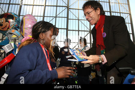 Sir Cliff Richard signe des autographes à Heathrow avant le décollage d'un jumbo de British Airways qui prend près de 200 enfants gravement malades et handicapés sur un vol DreamFlight en Floride. Banque D'Images