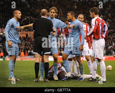 Jonathan Woodgate de Tottenham Hotspur retient les coéquipiers Jermaine Jenas et Alan Hutton (l) lorsqu'il discute avec l'arbitre Lee Mason après que Ricardo Fuller de Stoke City ait été fouillé par Michael Dawson (non illustré) Banque D'Images