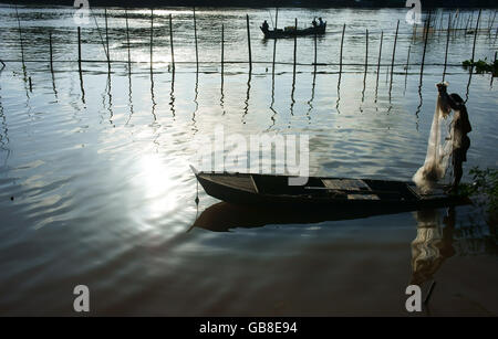 Belle landcape avec reflet de silhouette de pêcheur jeté un filet sur l'eau de surface dans la rivière cadre vertical Banque D'Images