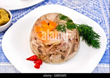 Boeuf et porc en gelée avec les carottes et le persil dans une assiette avec un pertsemey et l'aneth, la moutarde sur fond de ta lin Banque D'Images