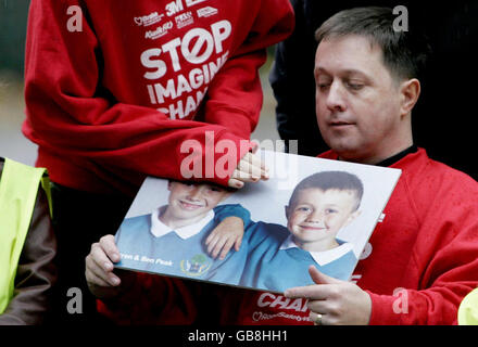 Amanda et Phil Peak tiennent une photographie de leurs deux fils Arron et Ben, lors du lancement de la semaine de la sécurité routière à l'école primaire du comté de Seedley à Manchester. Banque D'Images