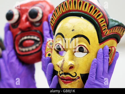 Les membres du personnel du Musée national d'Écosse présentent des masques Sri Lankais du XIXe siècle lors de la présentation à la presse de la nouvelle exposition du musée « Treasured - Wonderful Things, Amazing Stories » qui ouvre à Édimbourg le vendredi 14 novembre. Banque D'Images