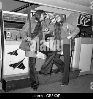 JJ porte un vêtement de tête et Louis Phillipe, porte ses créations d'Yves St Laurent à la répétition pour un défilé de mode de charité devant être présenté à la princesse Margaret au Planétarium de Londres, Baker Street. Les tenues sont : pantalon en jersey marron, chaussures en daim marron, chemises imprimées et gilets en tricot bleu marine avec veste imperméable. Banque D'Images