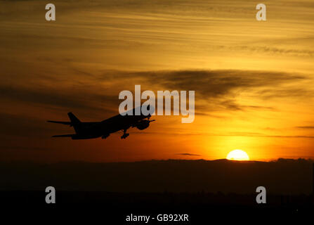 Un avion part de l'aéroport de Heathrow, Middlesex, au coucher du soleil d'hiver. Banque D'Images