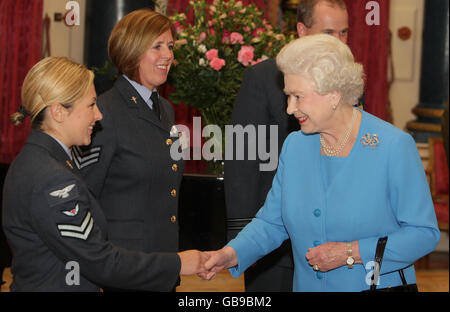 La reine Elizabeth II de Grande-Bretagne parle (de gauche à droite) au caporal Audrey McKenna, de l'équipe d'intervention paramédic déployable Aeromedical de la RAF, et au sergent de vol Karen McNeill, infirmière de l'escadron d'évacuation aéromédicale de la RAF, lors d'une réception au Palais de Buckingham à Londres, pour les personnes travaillant dans le secteur des soins de santé au Royaume-Uni. Banque D'Images