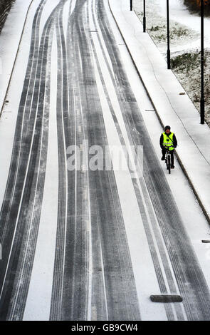 Aujourd'hui, un cycliste se rend sur une route enneigée à North Tyneside, près de Newcastle, alors qu'un front météorologique arctique touche la côte est. Banque D'Images