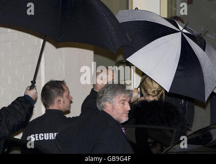 La chanteuse pop Britney Spears arrive aux Fountain Studios à Wembley, Londres, à l'abri de parasols alors qu'elle arrive pour sa performance X Factor. Banque D'Images