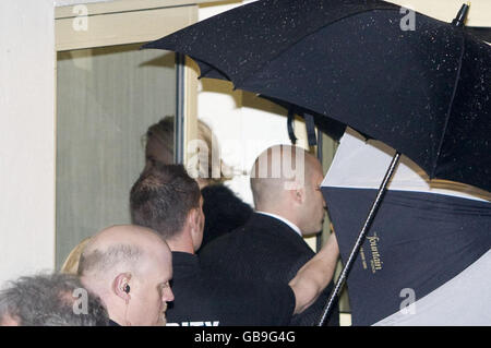 La chanteuse pop Britney Spears arrive aux Fountain Studios à Wembley, Londres, à l'abri de parasols alors qu'elle arrive pour sa performance X Factor. Banque D'Images