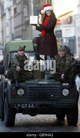 Mlle UK, Nieve Jennings avec le pte Greg Maitland, à gauche) et le Cpl Shug Hughes avec des cadeaux de Noël pour les soldats en Afghanistan lors d'une séance photo à l'extérieur de Marks and Spencer à Glasgow. Banque D'Images