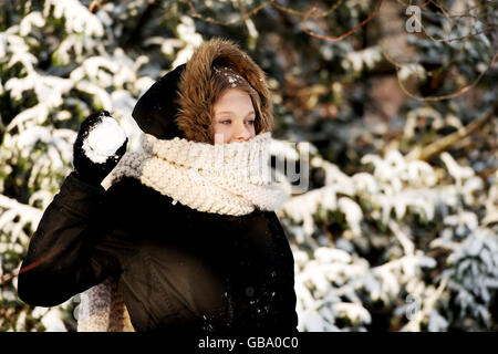 Young woman throwing snowball Banque D'Images