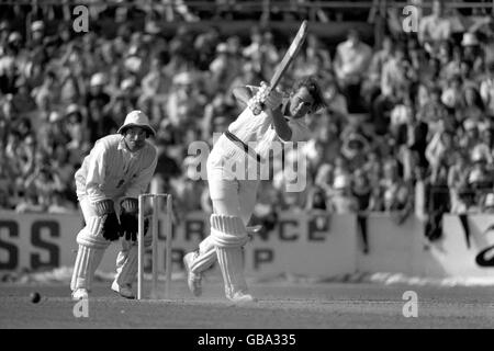 David Hookes (r), un australien, conduit le ballon jusqu'à la frontière, sous la surveillance du gardien de cricket de l'Angleterre Alan Knott (l) Banque D'Images