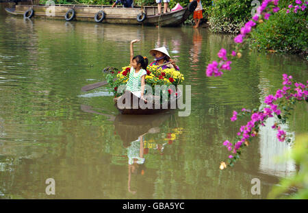 Le printemps venu, les femmes et les enfants la chaloupe à rames sur la rivière pour effectuer belle fleur forTet Banque D'Images