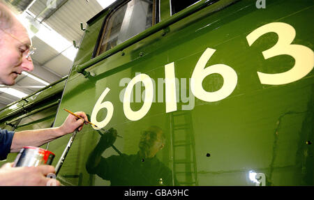 Le spécialiste de la peinture et de la décoration du Musée national des chemins de fer de York, Tony Filby, ajoute la touche finale au numéro de moteur du premier train à vapeur construit au Royaume-Uni depuis plus de 40 ans, la locomotive à vapeur Tornado. Banque D'Images