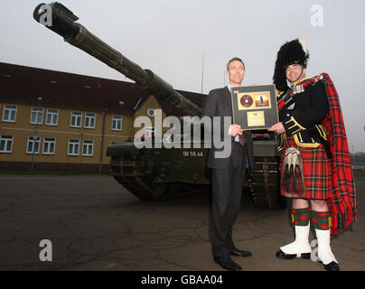 Le major de pipes Ross Munro, à droite, des Royal Scots Dragoon Guards reçoit un disque d'or du secrétaire d'État pour l'Écosse, Jim Murphy, pour le dernier CD de pipes et tambours du régiment, Spirit of the Glen:Voyage, lors d'une visite à leurs casernes après leur retour d'opérations en Afghanistan à la caserne Wessex à Bad Fallingbostel, en Allemagne. Banque D'Images