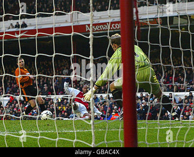 Soccer - FA Barclaycard Premiership - Arsenal / Wolverhampton Wanderers.Thierry Henry d'Arsenal place le ballon devant Michael Oakes, gardien de but de Wolverhampton Wanderers, pour marquer le troisième but Banque D'Images