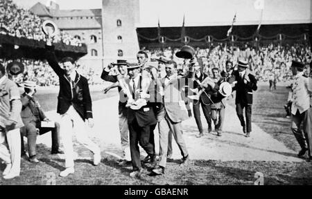 Les membres de l'équipe d'Afrique du Sud déportent leurs coéquipiers de la piste en jubilation après qu'ils ont gagné l'or et l'argent; Kenneth McArthur (or, r) et Christian Gitsham (argent, l) Banque D'Images