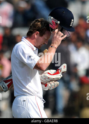 Paul Collingwood, de l'Angleterre, quitte le terrain après avoir été pris par le MS Dhoni de l'Inde au large du bowling d'Amit Mishra pendant 11 au cours de la troisième journée du deuxième test au Punjab Cricket Association Stadium, Mohali, Inde. Banque D'Images