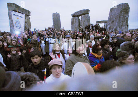 Vue générale d'une cérémonie du solstice d'hiver qui se déroule au lever du soleil à Stonehenge. Banque D'Images