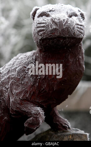 Une loutre en bois sculpté est recouverte de gel sévère au parc safari Blair Drummond de Stirling, lorsque la température est tombée sous le point de congélation. Banque D'Images